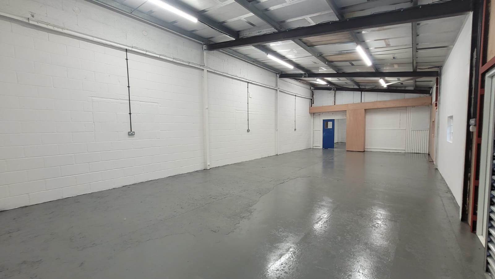 Industrial unit after full refurbishment — painted walls and floor, new lighting