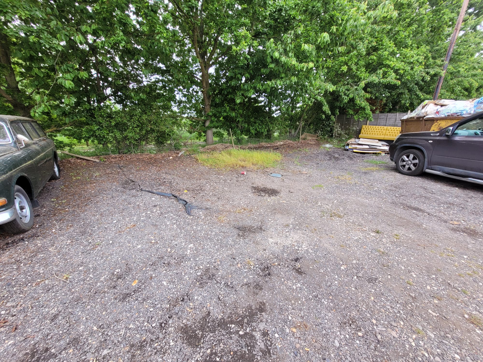 Car park before resurfacing, potholes and bare ground
