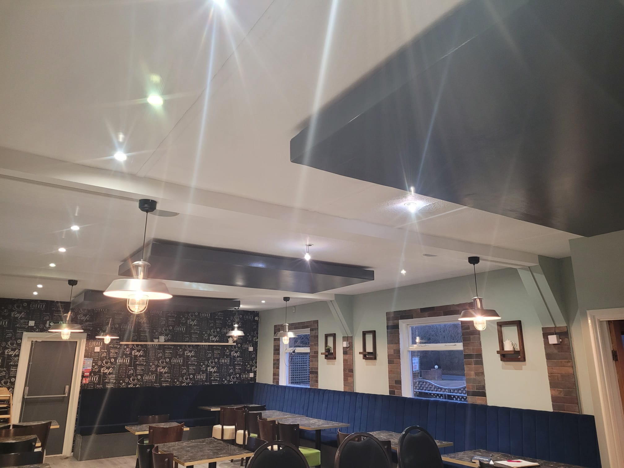 Restaurant interior with repaired LED panels and pendant lighting