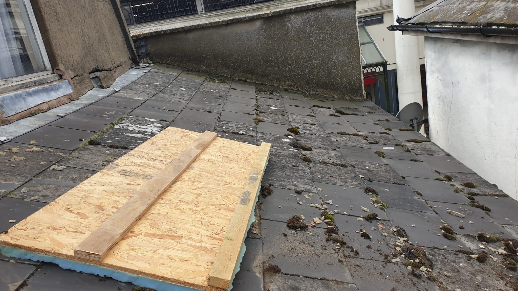 Slate roof covered in moss and debris before cleaning